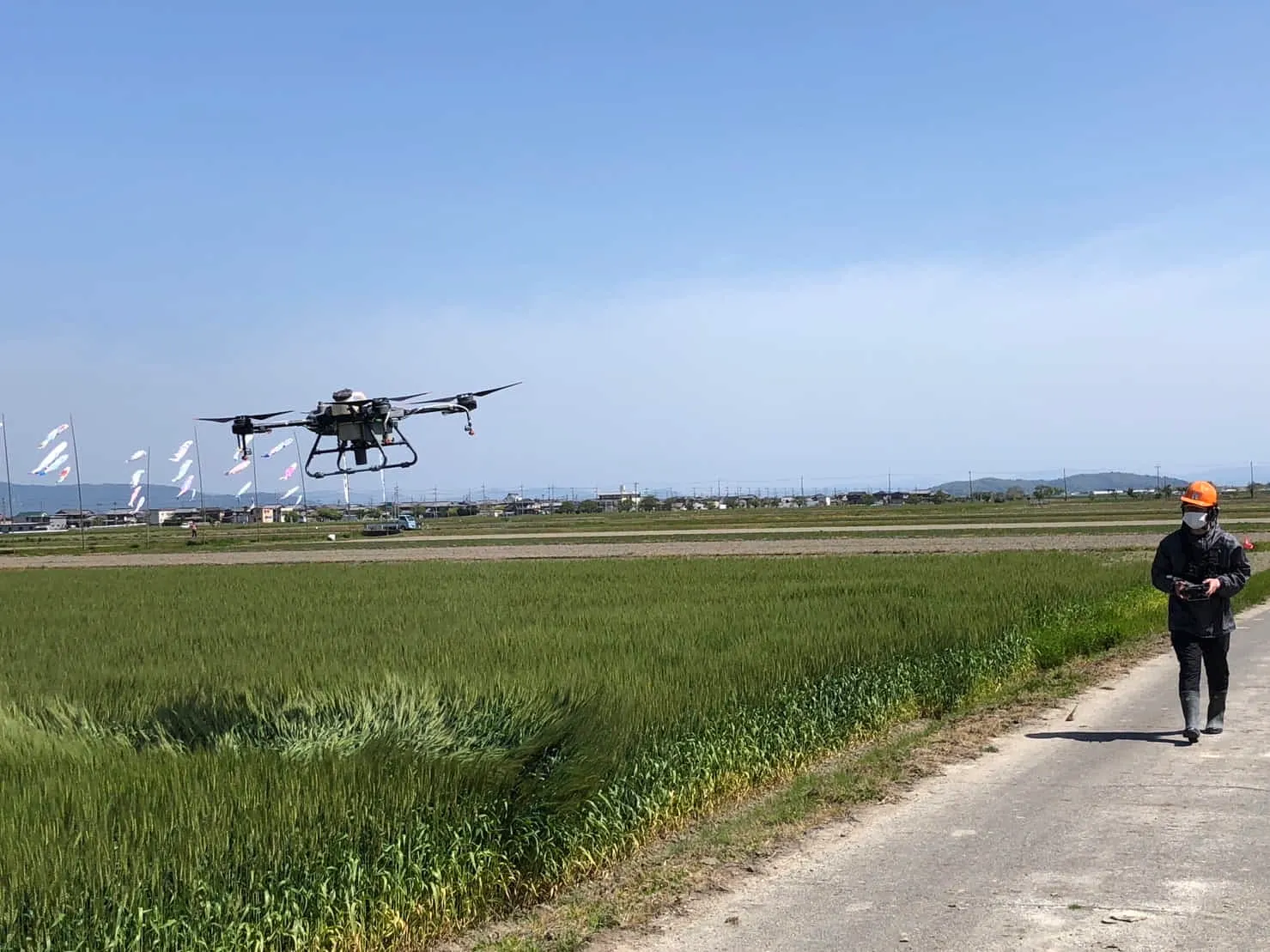 農地でドローン散布作業を行う